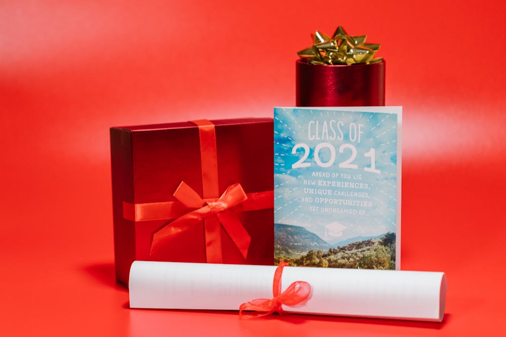 Red-themed image of graduation gifts with a diploma and Class of 2021 card.