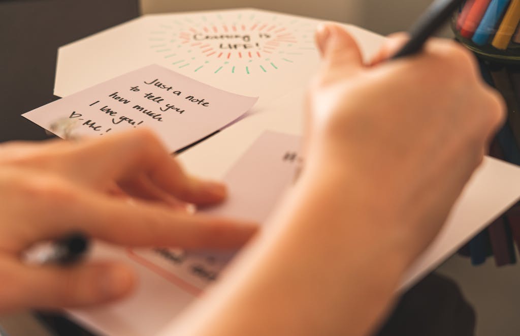 A close-up of hands writing a heartfelt note on a card, showcasing personal connection.