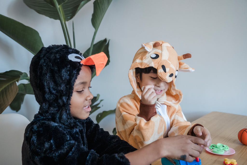 Two children in animal onesies playing with toys indoors, enjoying a fun and creative playtime.