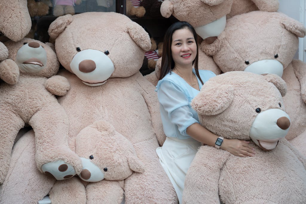 A woman happily poses with large plush teddy bears, showcasing a cozy and joyful scene.