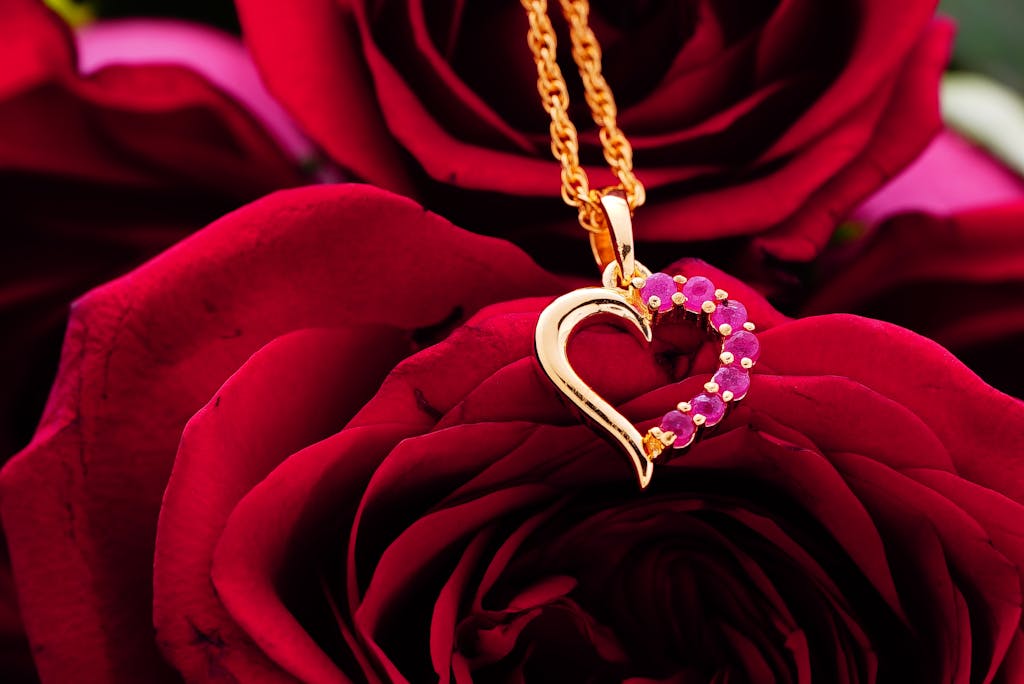 Bunch of bright red roses with golden accessory with pink gems placed above