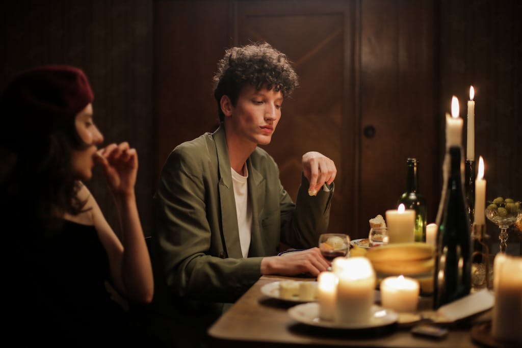 A couple enjoying a romantic candlelit dinner in a cozy, Parisian-inspired setting.