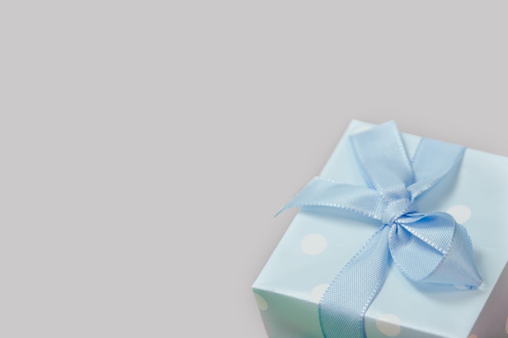 A close-up of a light blue gift box with a satin ribbon, perfect for celebrations.