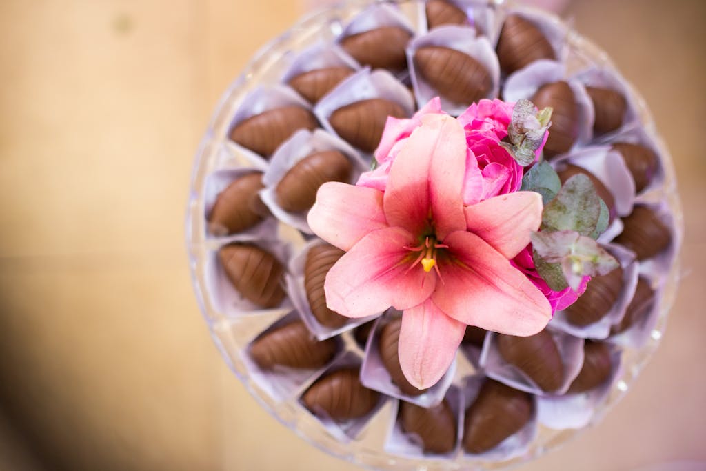 Top-down view of a decorative display featuring chocolates and vibrant flowers.